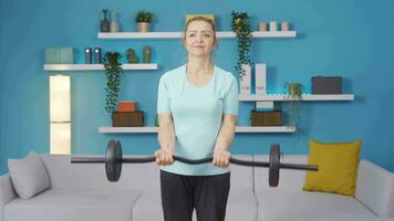 Woman working out her arm muscles using barbell. video