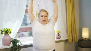 Obesity woman doing stretching exercises in front of the window. video