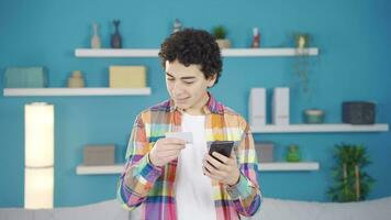 Cheerful boy paying with credit card. video