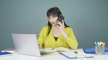 Woman using laptop nervously talking on the phone. video