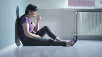 Cowardly woman drinks water with trembling hand. video