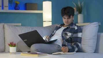 masculino estudiante estudiando a noche en ordenador portátil ligero. video