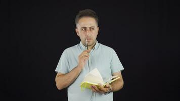 hombre con cuaderno piensa y toma notas video