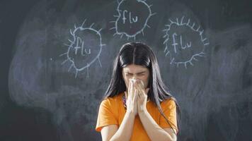 Woman writing flu on blackboard looks at camera and sneezes. video