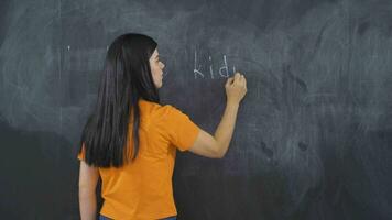 Woman with kidney failure writing on blackboard looks at camera helpless and suffering. video