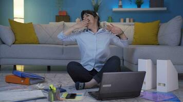 Home office worker woman yawns and relaxes at the camera. video