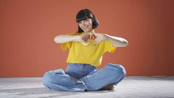 Woman making heart symbol for camera. video