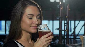 Gorgeous woman smelling and drinking delicious beer at the pub video