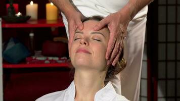 Happy woman enjoying relaxing head massage at thai spa center video