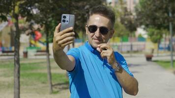 The man takes a selfie. Happy emoticon. video