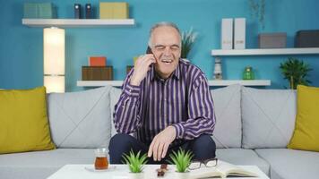 Happy old man talking cheerfully on the phone. video