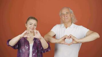 Couple making heart sign at camera. video