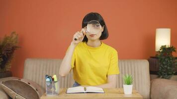 Woman looking at camera with magnifying glass. video