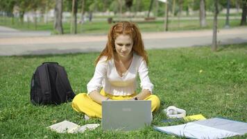 College student studying outdoors waving at camera. video