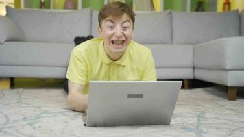 Young man is confused and shocked at home on laptop. video