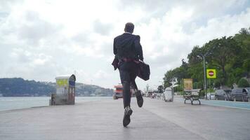 hombre en traje es corriendo por el mar. lento movimiento. video