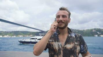 jung Mann reden auf das Telefon durch das Meer. video