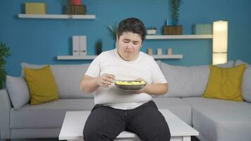 Obesity boy crying eating junk food feels bad. video