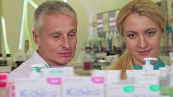 Two chemists checking products for sale at the drugstore video