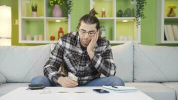 Low-budget young man grappling with high-priced bills. video