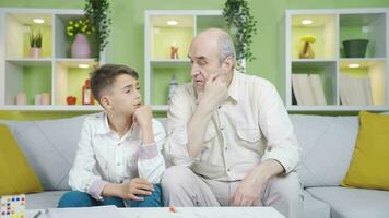 Grandfather and grandson thinking about a topic. They consult. video