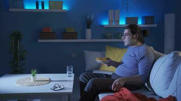 When the funny man rejoices at the TV, the chips are spilled on the floor. video