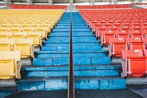 vacío naranja y amarillo asientos a estadio,filas pasarela de asiento en un fútbol estadio foto