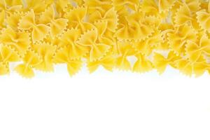 Scattered raw pasta farfalle isolated on white background. Food background, italian cuisine photo