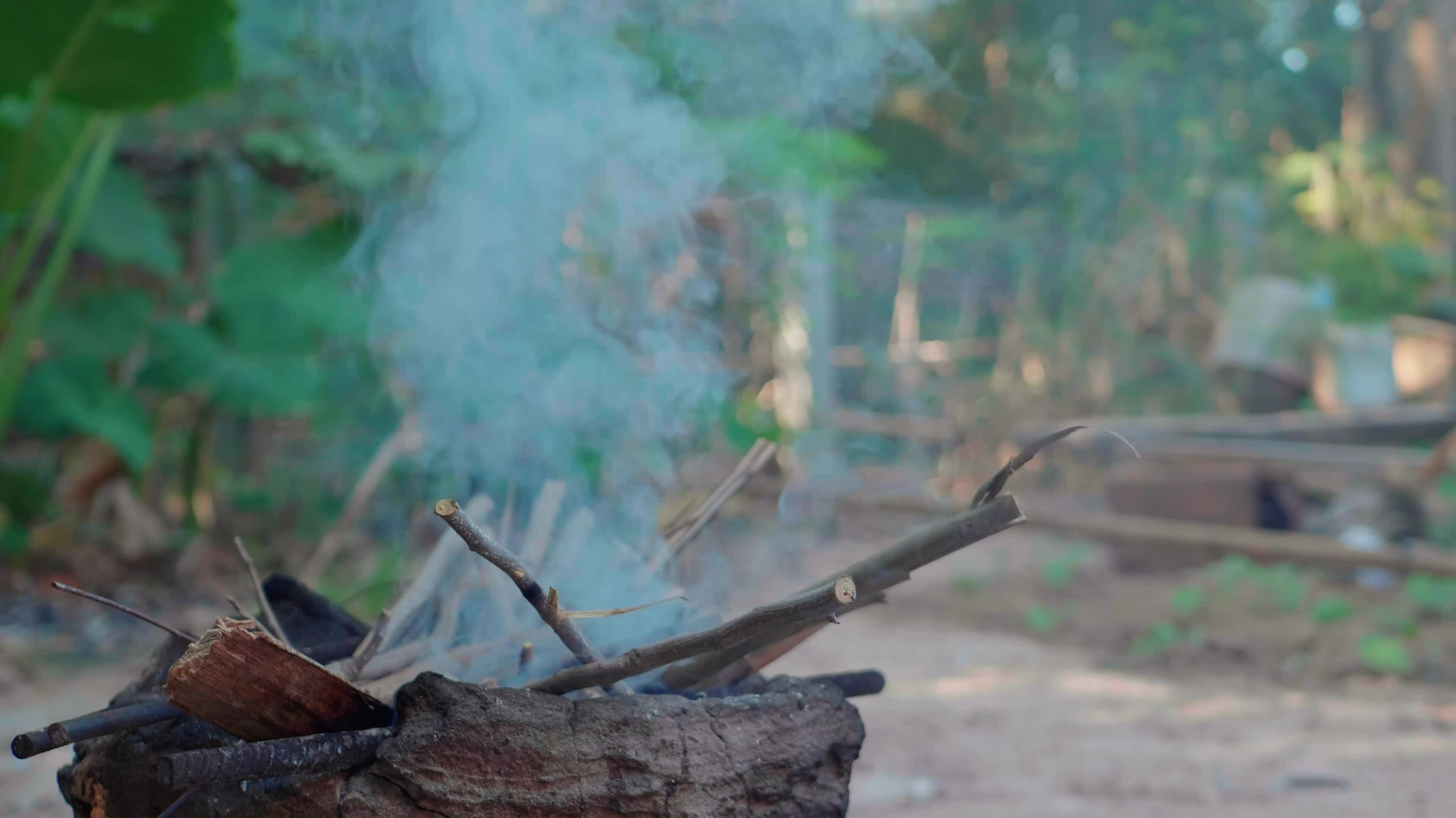 Light a fire to cook rice using firewood as fuel. 33063369 Stock Video at Vecteezy