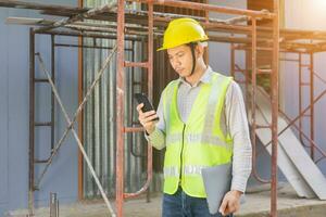 un ingeniero de sexo masculino mira el plano del piso en el sitio de construcción. foto