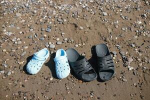 hijo y padre es zapatillas en el playa foto