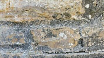 A close up of a stone wall with some peeling paint texture photo