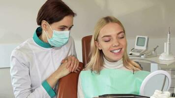 professionale dentista e sua paziente sorridente per il telecamera video