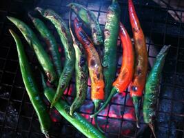 local Thai northern style cooking chili sauce and grilled chili in stone mortar photo