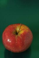 un rojo manzana en un verde superficie foto