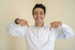 joven indonesio Rizado hombre vestir blanco ropa con miniatura pose. foto