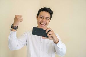 Indonesian office employee wear white clothes happy playing game when working hour. photo