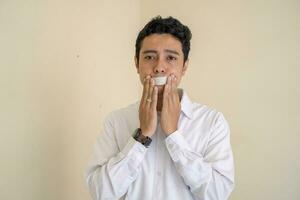 joven indonesio Rizado hombre vestir blanco ropa con aislado boca pose. foto