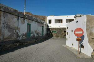 a street with a red stop sign and a white building photo