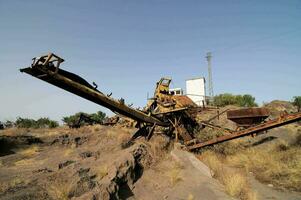 a large machine sitting on top of a dirt field photo