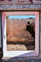 a window in an old building with pink paint photo