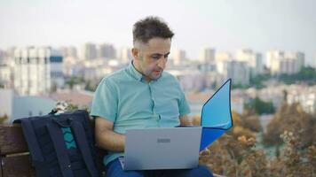 Businessman sitting in the park and doing research. video