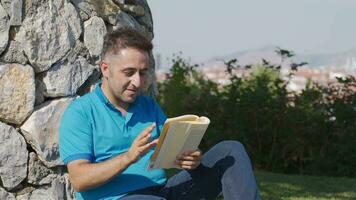 culto y intelectual hombre leyendo un libro en el parque. video