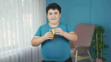 Obesity boy drinking diet drink looking at camera. video