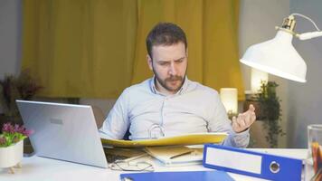 Home office worker man looking at the file angrily. video