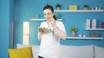 un persona quien dietas y come saludablemente ella come ensalada y bailes video