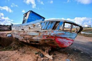 an old boat sits on the ground in a field photo