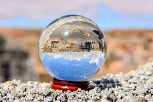 a glass ball with a blue sky and a mountain in the background photo