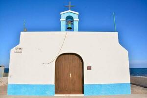 a small white church with blue and white walls photo