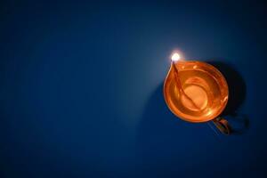 Happy Diwali. Diya on blue background. Traditional oil lamp. Celebrating festival of light. photo